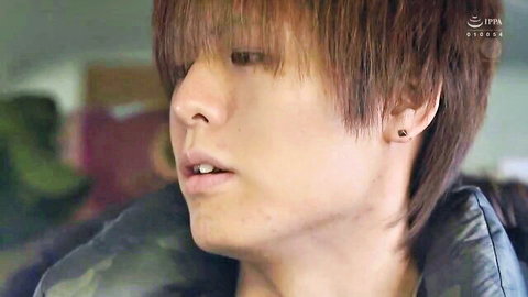 Close-up of handsome young Asian man with bangs and parted lips in profile view