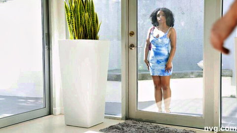 Curvy ebony babe in tight blue mini dress teasing at glass door with hand on handle