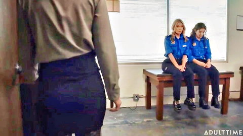 Casey Calvert approaches tied Victoria Voxxx and Nicole Aria in police uniforms