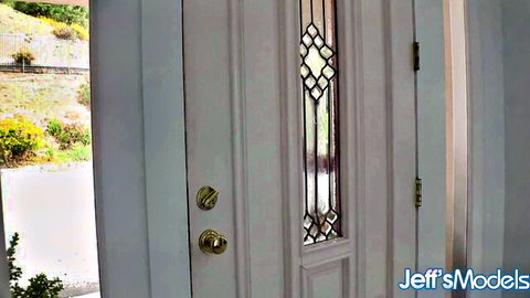 Kinky Katie chubby model at open front door with outdoor view