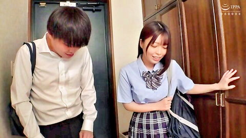 Japanese schoolgirl in sailor uniform reaching for locker with male classmate in hallway