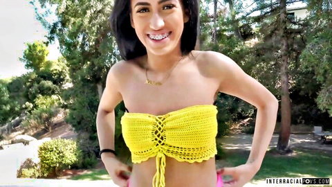 Edible Aubrey in yellow crochet bikini top, smiling outdoors