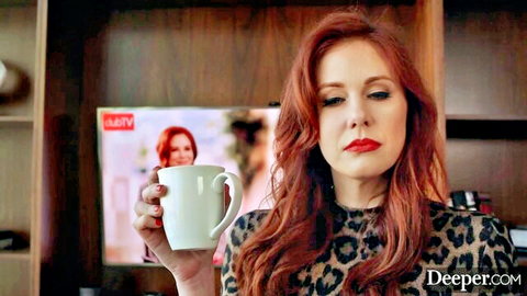 Redhead woman in leopard print top holding mug, thoughtful gaze in Muse Episode 1