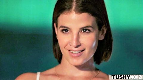 Gabbie Carter smiling close-up in white top, TUSHY studio