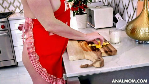 Curvy blonde MILF bends over exposing big bare ass under frilly red apron while cutting pineapple