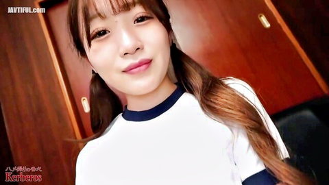 Cute Asian e-girl with bangs and pigtails smiling in tight white school uniform top