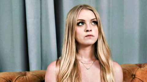 Blonde woman with long hair and cleavage in seductive side glance