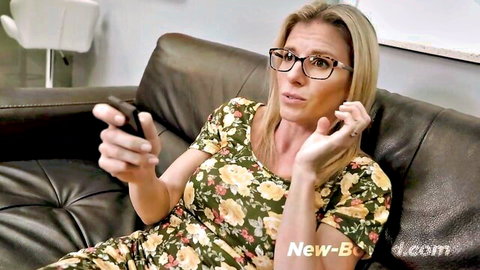 Blonde MILF Cory Chase in floral dress, surprised on couch holding phone
