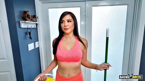 Sexy brunette maid in tight pink bra and orange shorts holding mop and bucket