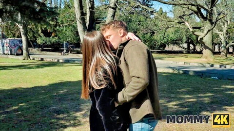 Hot long-haired MILF in black jacket passionately kisses young stud outdoors for Mommy 4K.