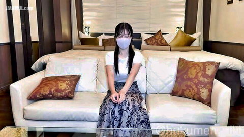Beautiful Japanese woman in white top, blue skirt and mask, sitting solo