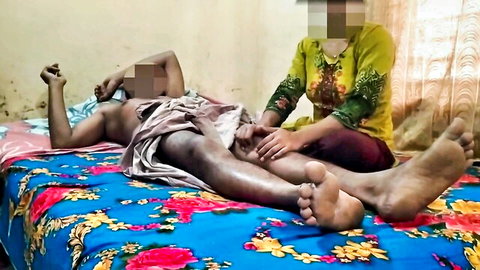 South Asian woman massages naked man's thighs near censored cock during steamy bedroom session