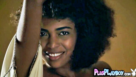 Smiling curvy ebony babe with big natural tits teases in off-shoulder top striptease pose