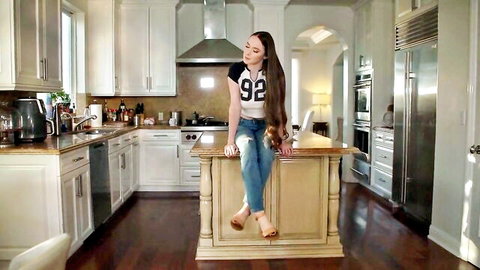 Hazel Moore posing seductively on counter in crop top and jeans
