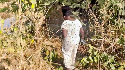 Chikaph in white polka-dot outfit walking through bushes in outdoor threesome tease