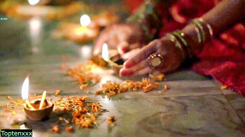Tabinash lighting diyas in red saree with marigolds, traditional Indian festival vibe