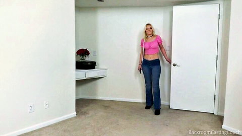 Blonde babe in pink off-shoulder top and jeans opening door in Backroom Casting Couch room