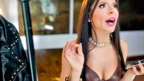 Seductive brunette in leather bra exhales smoke with open mouth showing deep cleavage and long hair
