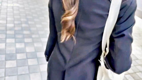 Back view of cute Asian job-hunting student in black suit with long wavy brown hair