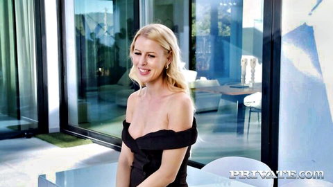Blonde MILF Lynna Nilsson smiling in sexy black off-shoulder dress