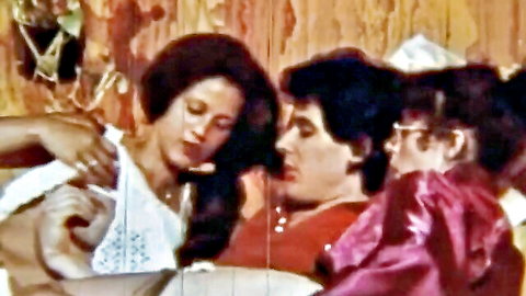 Retro orgy scene with black woman exposing breasts in group intimacy