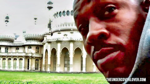 Intense close-up of black man in hoodie staring at ornate Royal Pavilion building in Brighton