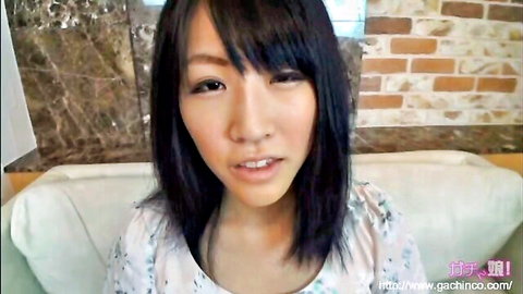 Cute Japanese amateur girl in floral blouse smiling at camera