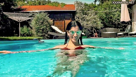 Brunette Latina in red bikini floating in pool with wet perfect body and small tits