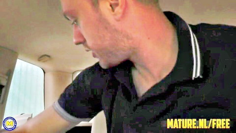 Mature man in black polo shirt looking sideways in car interior