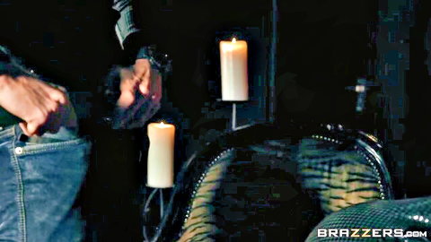 Man with hand down open jeans near candlelit chair with spread legs babe in dark room