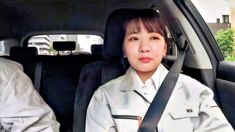 Cute Japanese woman in work uniform smiles in car backseat next to male coworker
