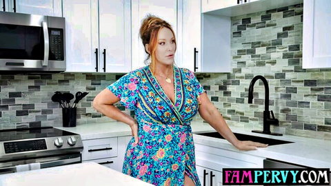 Curvy redhead MILF stepmom poses teasing big tits in floral dress kitchen