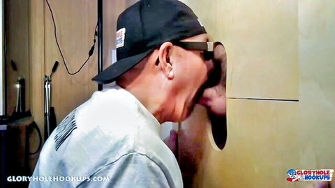 Asian guy in cap and glasses opens wide mouth for thick ebony cock through glory hole