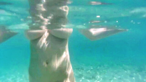 Julia Boin nude underwater, floating with large breasts visible in clear blue water