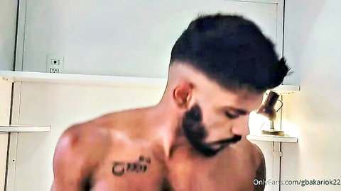 Bearded Marcelo Caiazzo shirtless with chest tattoo posing seductively