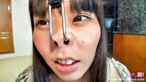 Cute Asian woman with chrome nose clamp, wide-eyed tease, JAV style