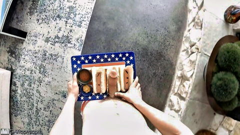 POV trans woman in white dress holding phallic 4th of July hot dogs on flag tray