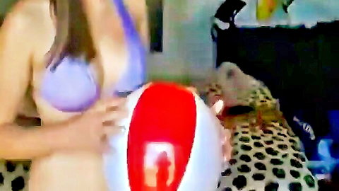 Busty amateur babe in purple bikini squeezes red beach ball between her huge tits