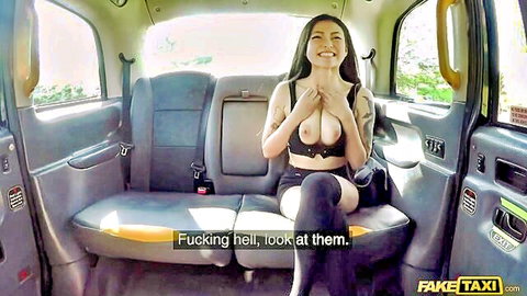 Asian babe in Fake Taxi squeezes her exposed perky tits with tattooed hands smiling at POV camera