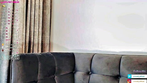 Busty amateur webcam girl exposes huge bare tits and hard nipples smiling on couch
