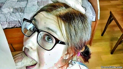 Evie Davis with glasses and braces giving intense oral sex