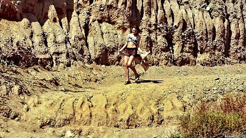 Ariel Winters in striped crop top and shorts walking in desert