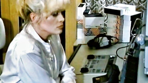 Blonde woman in satin blouse at desk in vintage 1985 porn