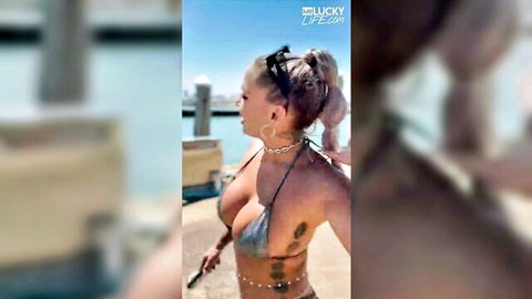Curvy blonde babe with huge tits spilling from skimpy silver bikini on yacht