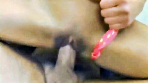 Asian woman with bush inserts pink dildo close-up