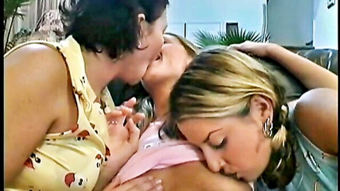 Brunette MILF kissing two blonde babes in intimate lesbian threesome embrace