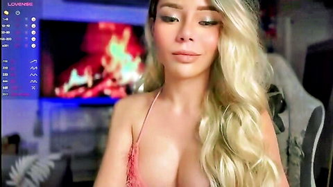 Blonde babe with big tits in pink slip showing deep cleavage on webcam