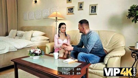 Brunette pigtails girl in pink top flirts intimately with older man touching her hand on couch