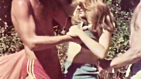 Vintage petite blonde flashing small tits to two muscular men in forest threesome.