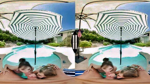 Two young fair-skinned blondes in bikinis passionately kissing by the pool under striped umbrella